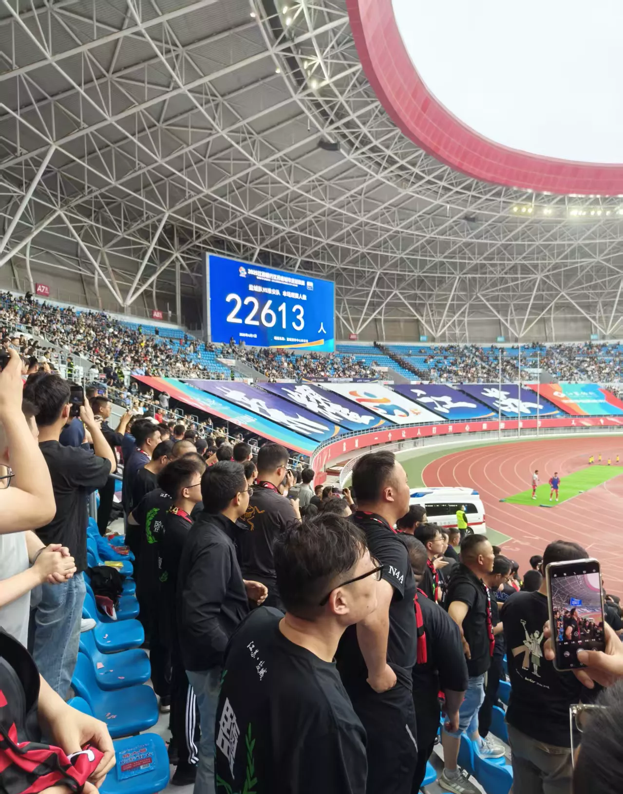 足球比赛现场热闹非凡，球迷们高呼助威声